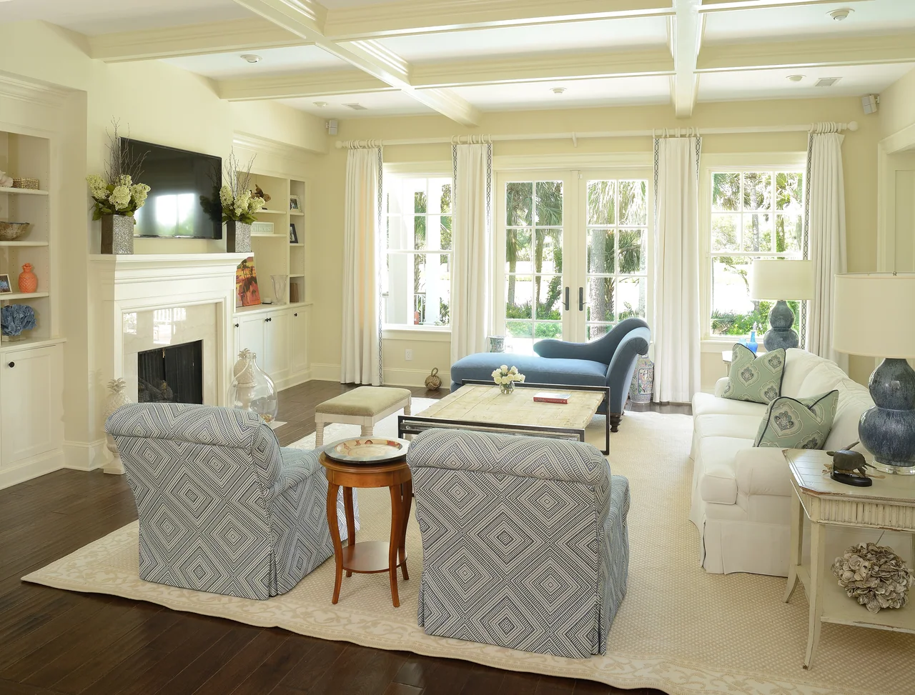 Living room with blue patterned seating and a coffered ceiling